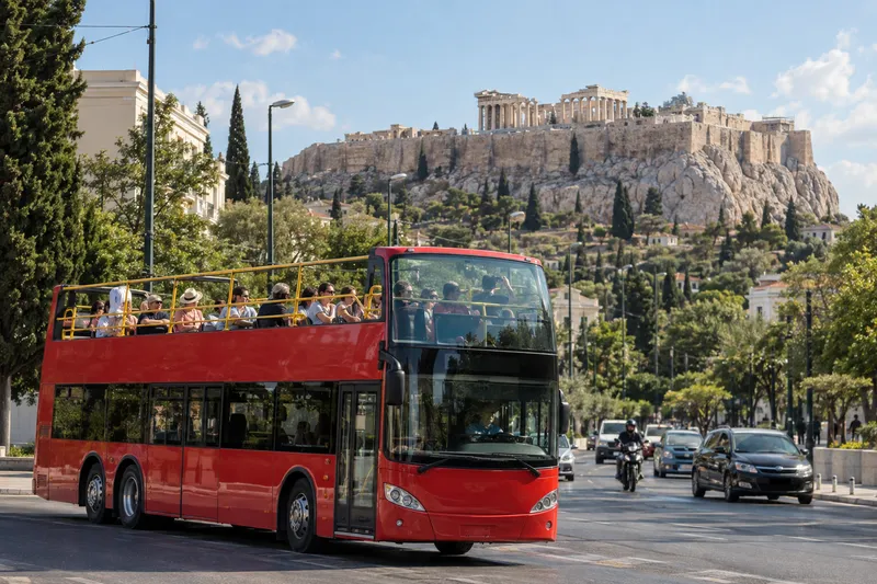 Open-top sightseeing bus passing the Acropolis in Athens