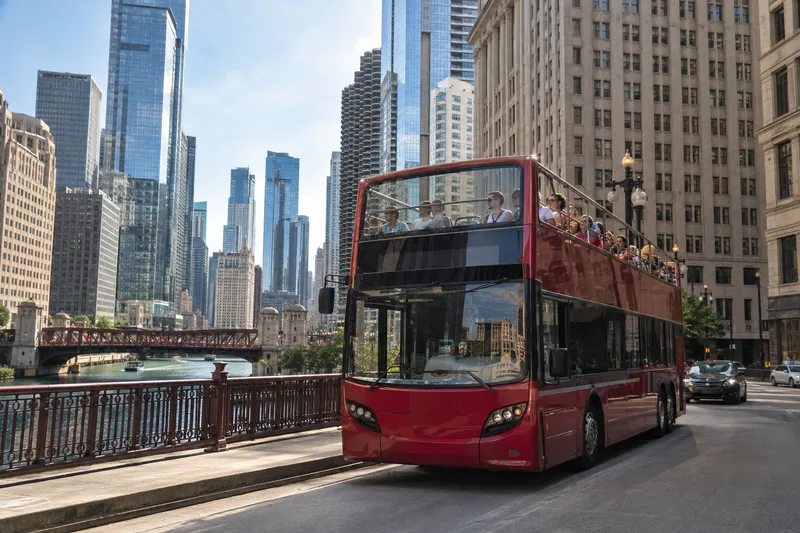 Open-top double-decker sightseeing bus driving through downtown Chicago