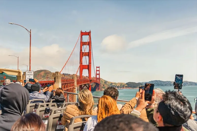 Tourists on open-top sightseeing bus crossing the Golden Gate Bridge