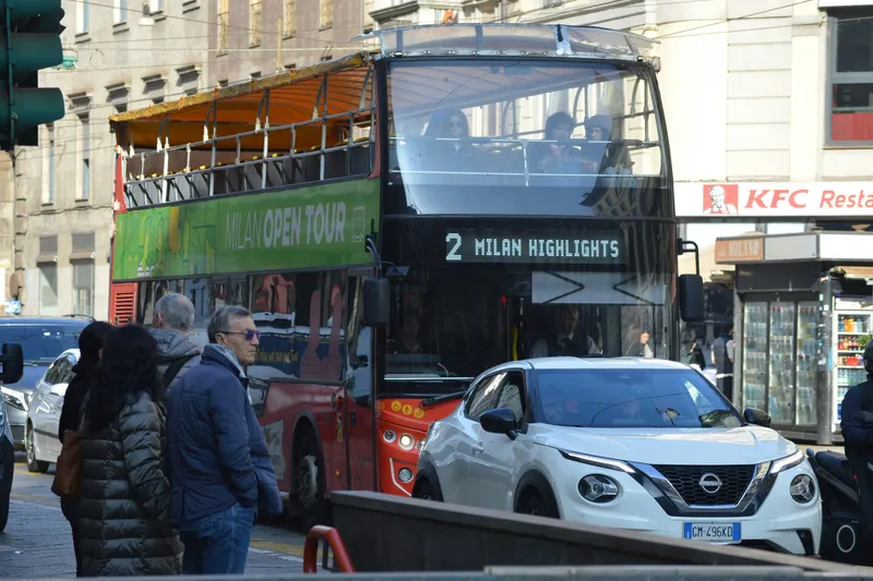 Red open-top double-decker sightseeing bus in Milan on route 2