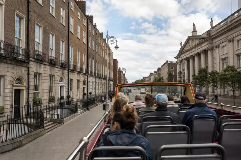 Open-top sightseeing bus traveling through central Dublin