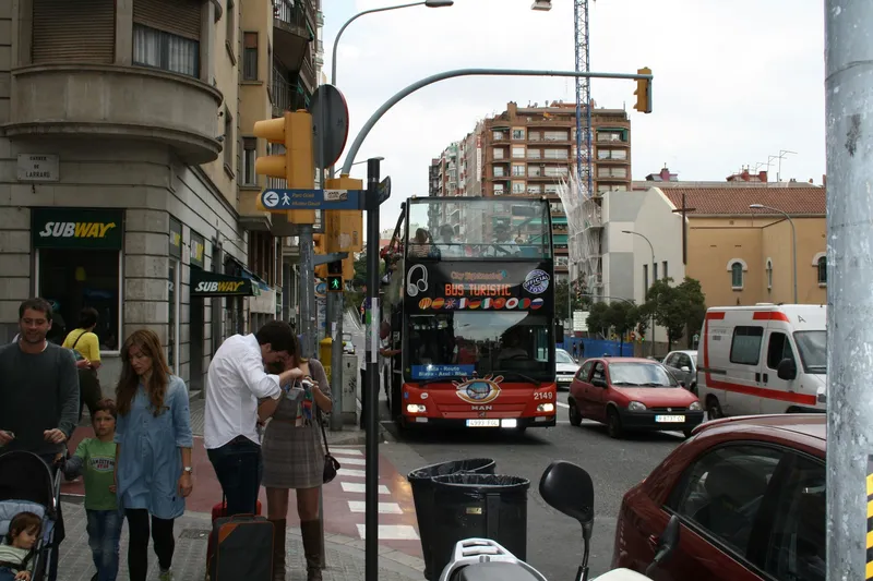 Open-top double-decker sightseeing bus driving through historic city center