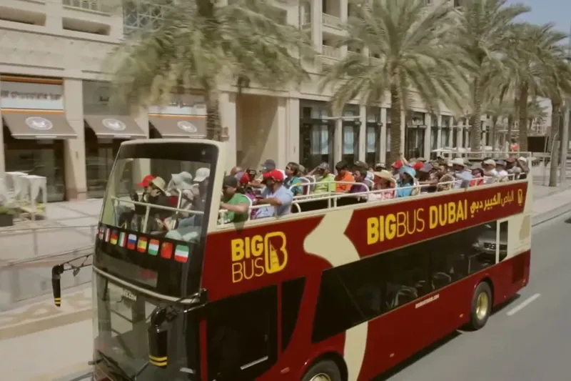 Open-top double-decker hop-on hop-off sightseeing bus full of tourists on city street