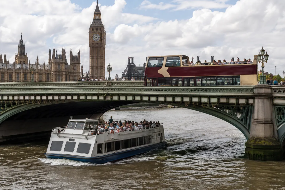 Open-top sightseeing bus and river cruise boat on the Thames by Westminster Bridge