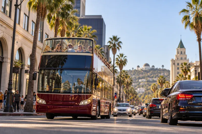 Open-top sightseeing bus on a palm-lined Los Angeles boulevard
