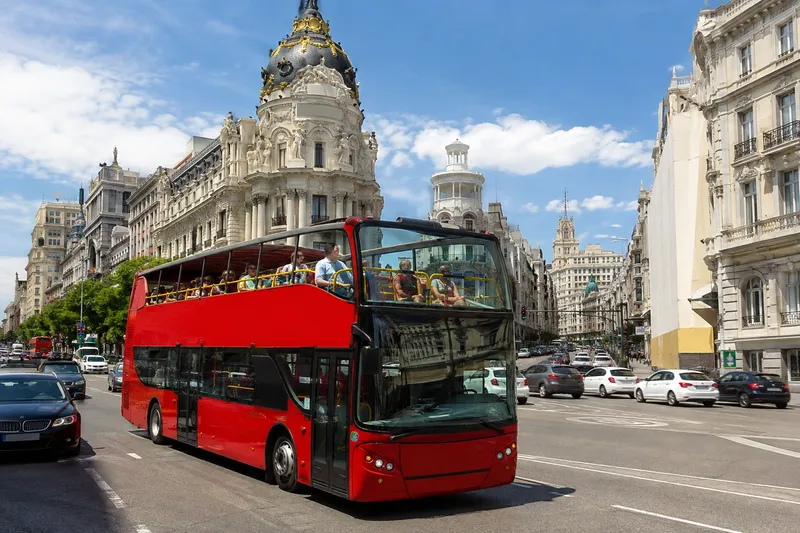 Open-top sightseeing bus driving through central Madrid