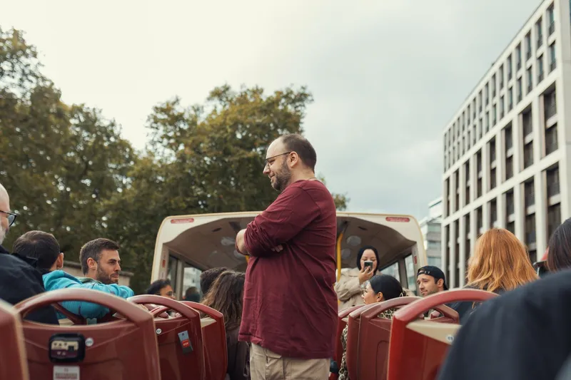 Passengers riding on the upper deck of an open-top sightseeing bus