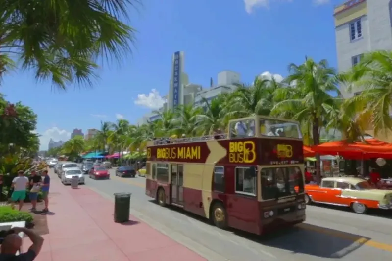 Open-top hop-on hop-off sightseeing bus on a sunny Miami street