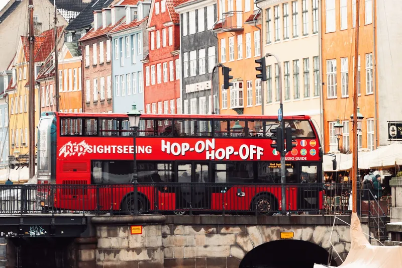 Red double-decker sightseeing bus crossing a bridge in central Copenhagen